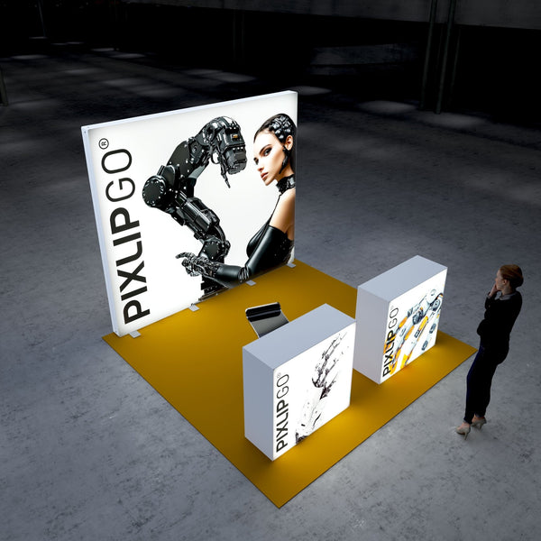 A futuristic Pixlip GO exhibition booth featuring a large illuminated panel showcasing a robotic arm interacting with a woman styled in a cybernetic theme. The booth includes two illuminated counters with graphics of mechanical hands and robotic designs, all placed on a vibrant yellow floor. A person observes the booth thoughtfully.